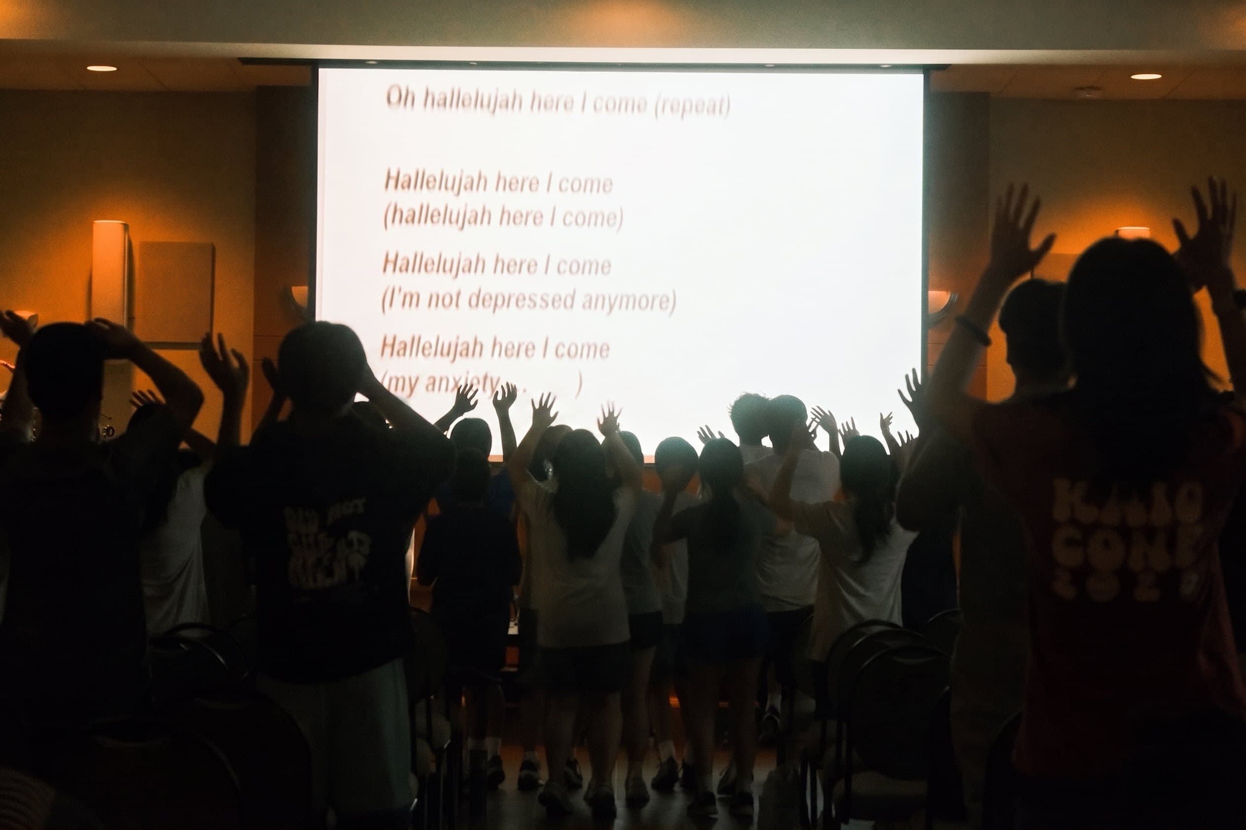 Students worshiping with hands raised at KAIO